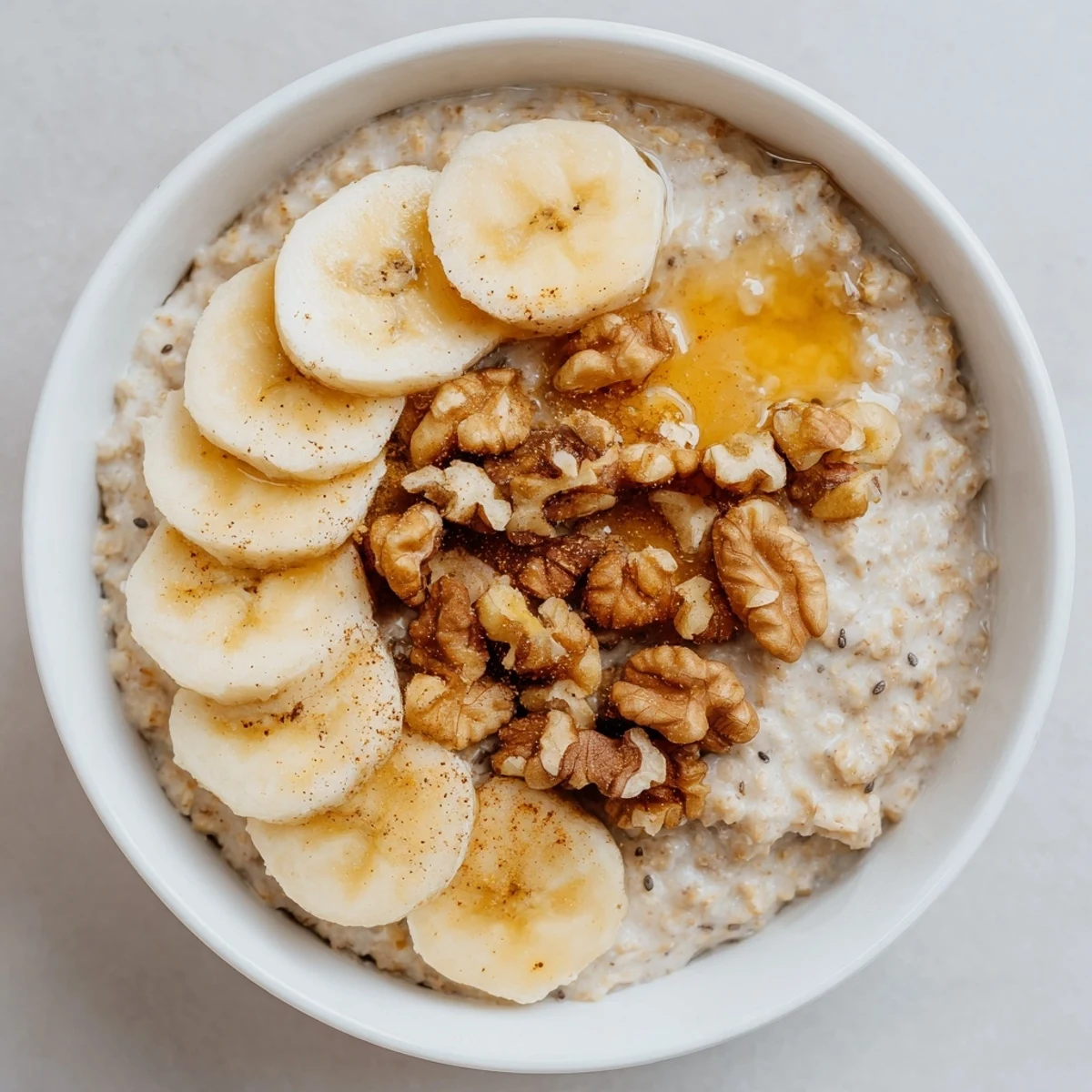 Steaming hot microwave banana oats, garnished with fresh banana slices, ready for breakfast.