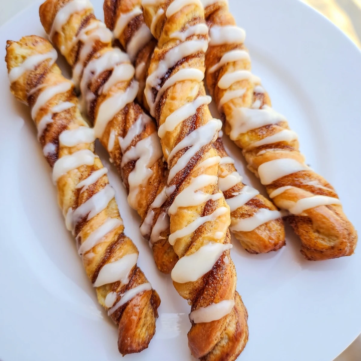 Golden air-fryer cinnamon roll twists, warm and glazed, perfect for a quick and easy breakfast idea.