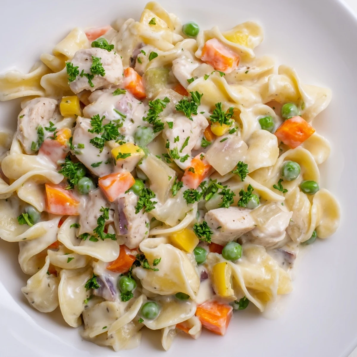 A close-up of creamy chicken and egg noodles, inviting with fluffy noodles and cooked vegetables.
