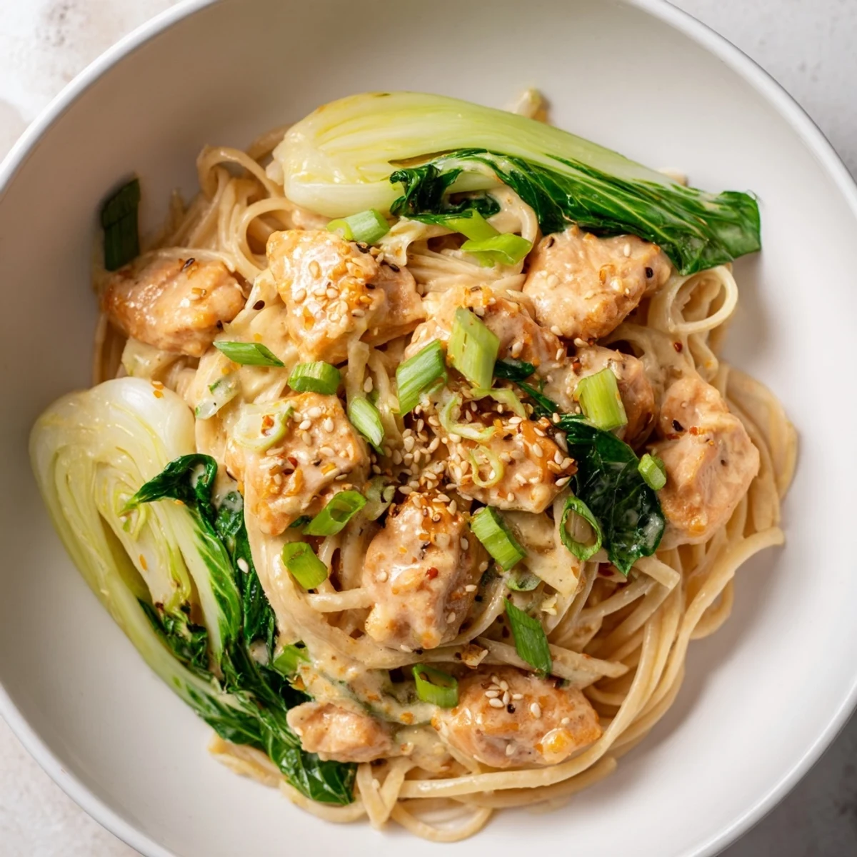 Golden brown salmon pieces rest atop the delicious miso butter salmon pasta with vibrant green bok choy.
