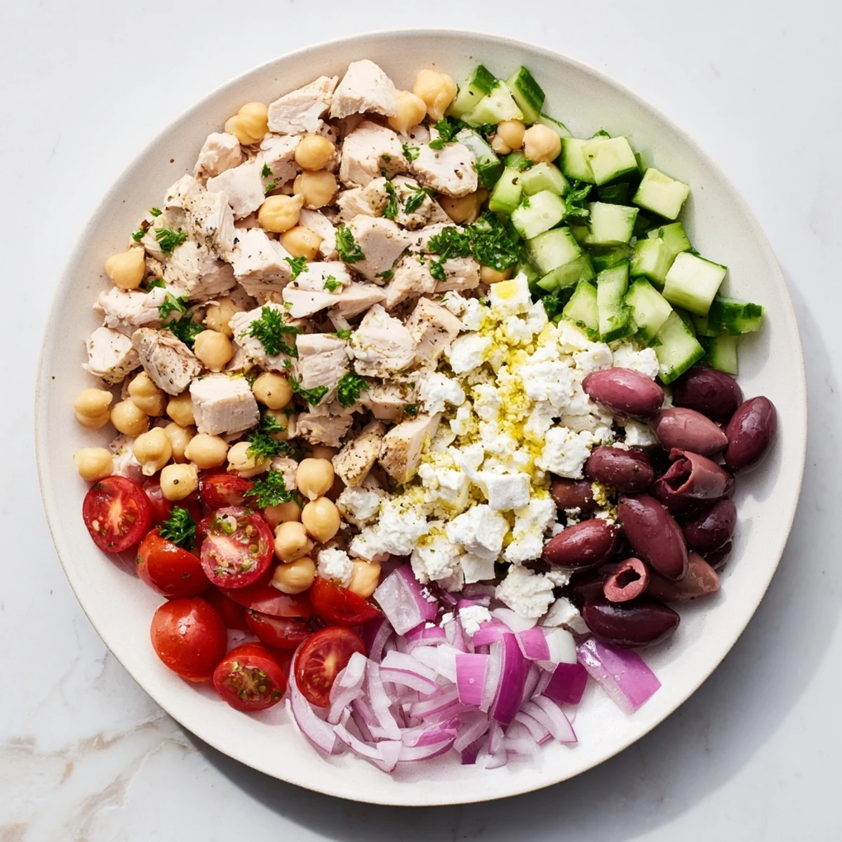 Savory Mediterranean Chickpea Chicken Salad served in a white bowl, garnished with parsley, perfect for a light lunch.
