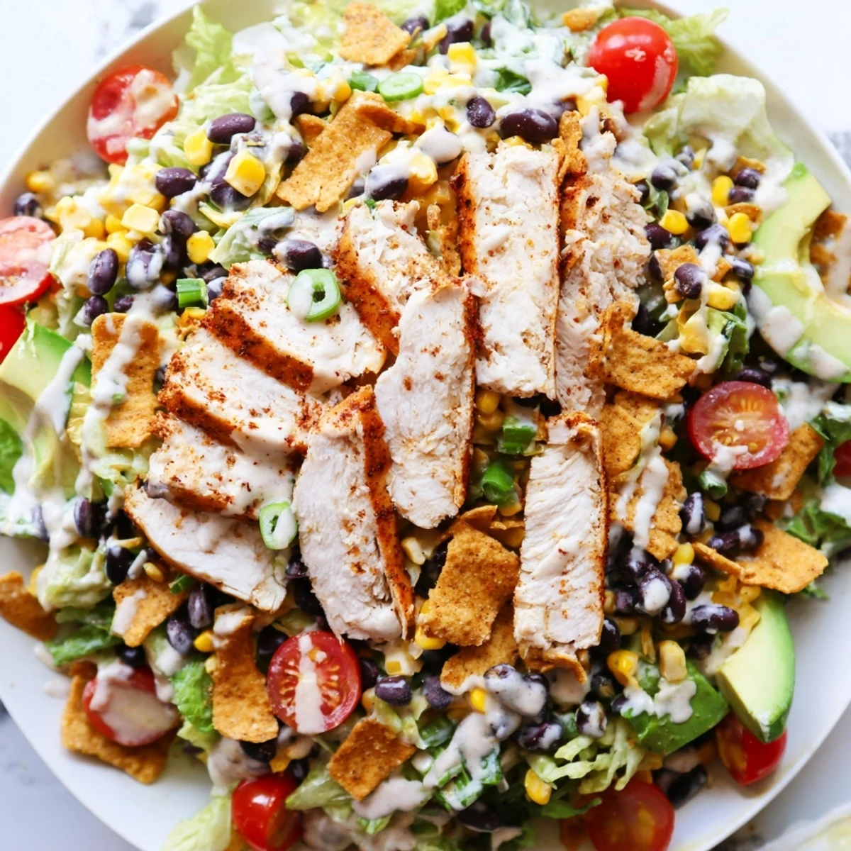 A vibrant bowl of Crunchy Taco Chicken Salad featuring shredded cheese, cherry tomatoes, and a Tex-Mex inspired presentation.
