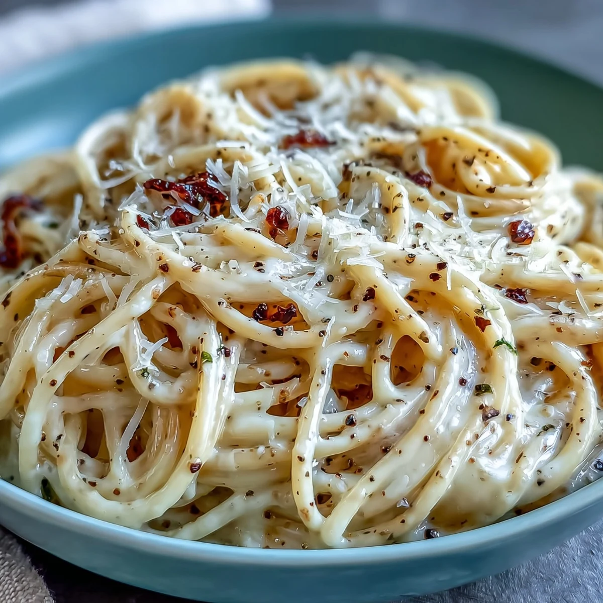 Plate of Cacio e Pepe, with spaghetti coated in a creamy Pecorino Romano sauce flecked with freshly cracked black pepper.