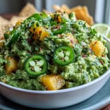 Easy homemade guacamole recipe featuring ripe avocados, juicy mango, and zesty jalapeño, served with crispy tortilla chips for dipping.