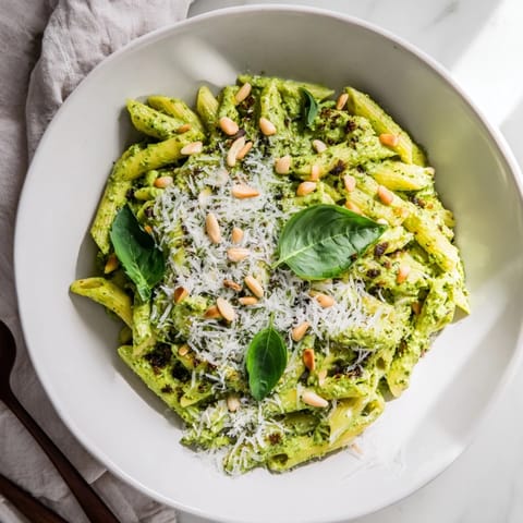 This photo features a steaming bowl of The Best 15-Minute Creamy Pesto Pasta, ready to devour!