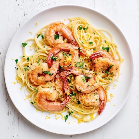 Platter of homemade Garlic Butter Shrimp Linguine, showcasing pink shrimp and glossy sauce over perfectly cooked pasta.