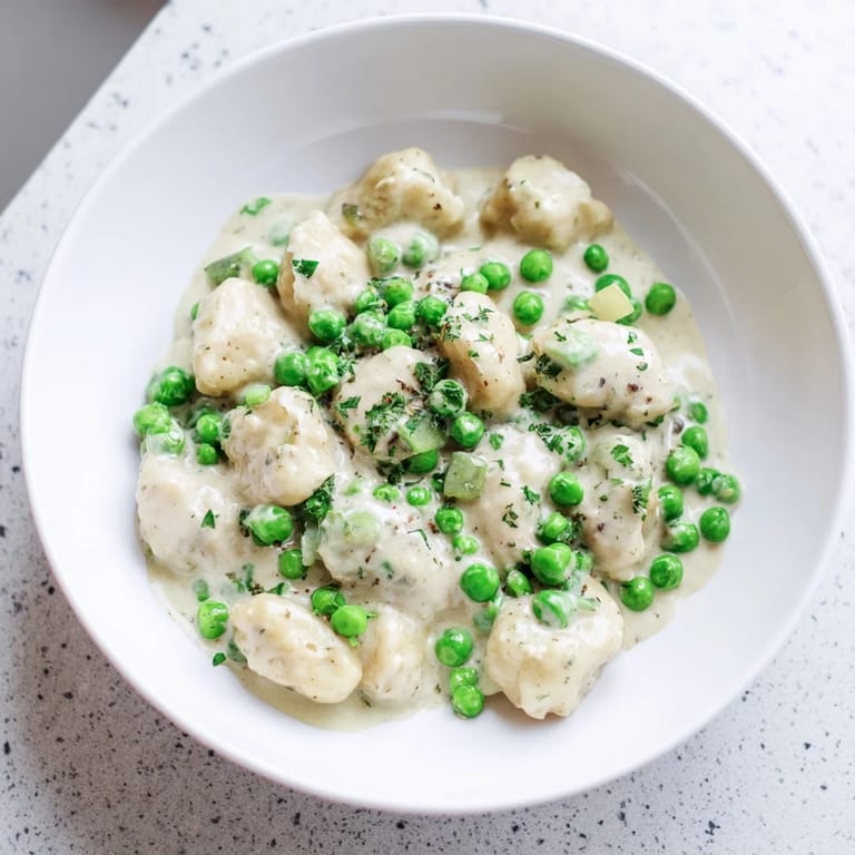 The creamy Parmesan Orzo features glistening, perfectly cooked orzo and vibrant green peas.