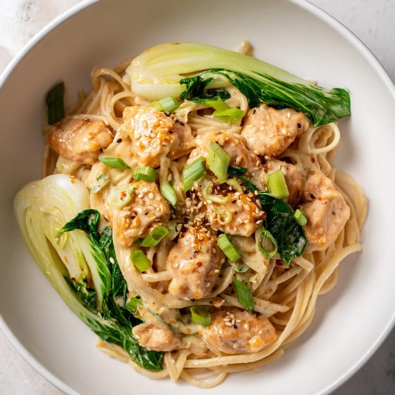 Golden brown salmon pieces rest atop the delicious miso butter salmon pasta with vibrant green bok choy.