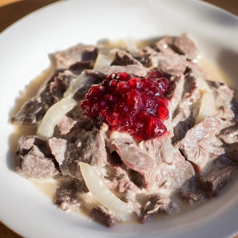 Savor the aroma of Finnish Reindeer Stew, slow-cooked reindeer, and onions, served with lingonberries.