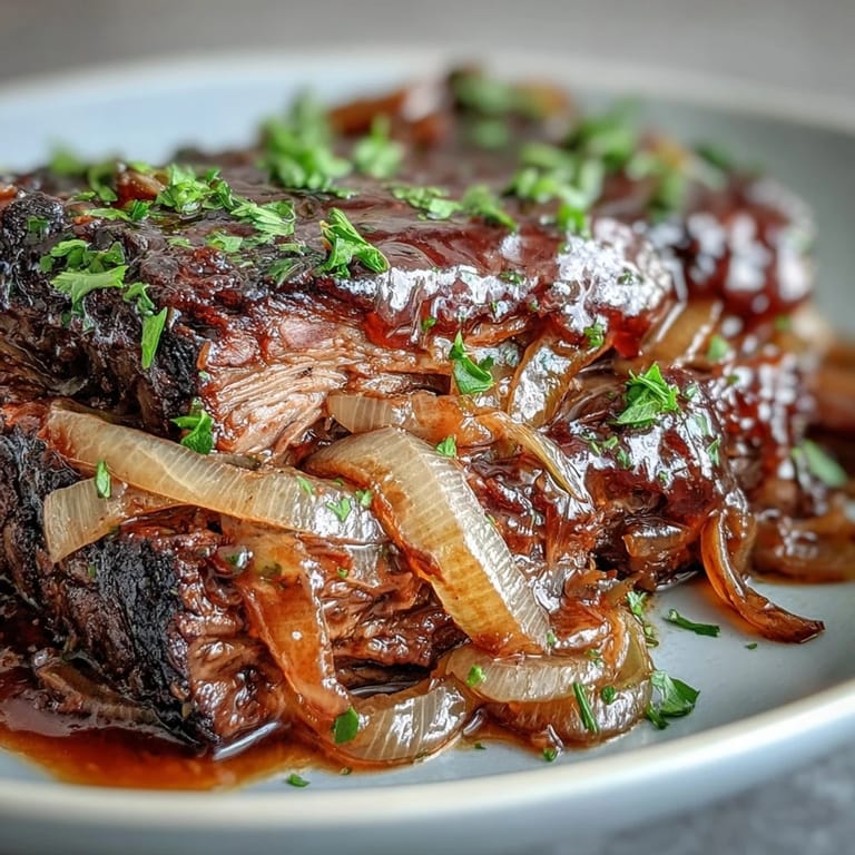 Platter of Savory Crock Pot French Onion Pot Roast with melty cheese and thyme, perfect over mashed potatoes or crusty bread.