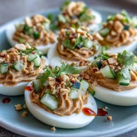 Thai Peanut Deviled Eggs with Cucumber Relish: creamy eggs topped with spicy peanut sauce and fresh cucumber relish.  